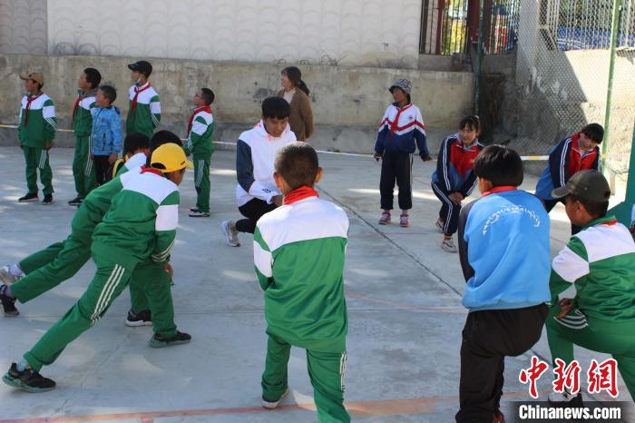 图为17日，西藏日喀则市桑珠孜区第三小学学生在攀岩教练的指导下进行热身。　次仁片多 摄