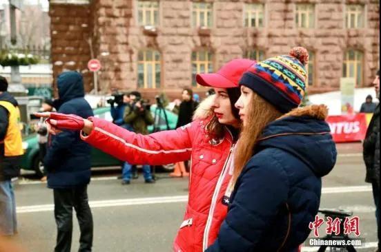 资料图：乌克兰首都基辅举行的一场女子汽车拉力赛。比赛吸引了40多名选手参加。图为观赛中的女车手表情“严阵以待”。/p中新社记者 史天昊 摄