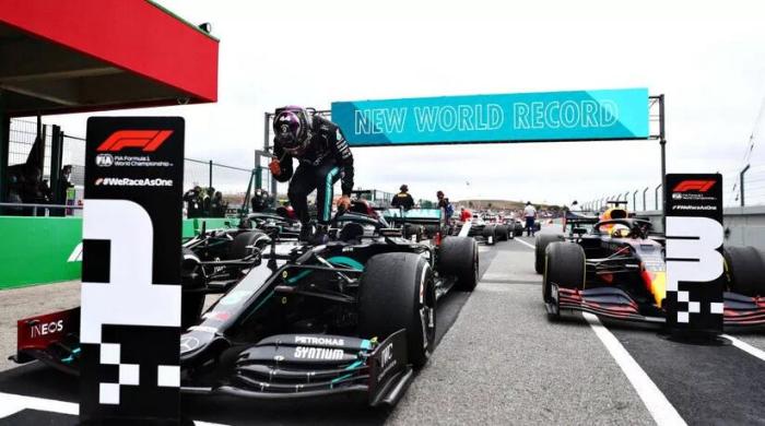 汉密尔顿赛后站在赛车上庆祝胜利。图片来源:F1官方微信公众号 汉密尔顿赛后站在赛车上庆祝胜利。图片来源:F1官方微信公众号