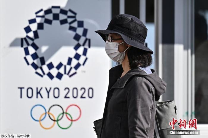 资料图:图为一名女士走过2020年东京奥运会海报。 资料图:图为一名女士走过2020年东京奥运会海报。