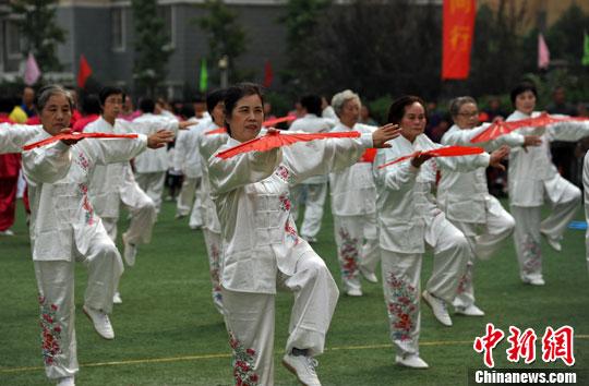 资料图：2013年10月19日，安徽省合肥市庐阳区林店街道老人健身代表队表演《红梅赞》。/p中新社发 韩苏原 摄