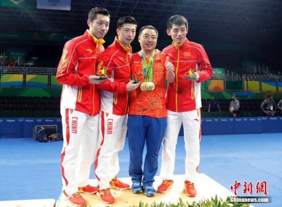 资料图：2016年8月17日，2016里约奥运男子乒乓球团体赛决赛举行，中国队最终以总比分3：1的成绩战胜日本队获得冠军。许昕(左一)、马龙(左二)、刘国梁(右二)、张继科在领奖台上合影。/p中新网记者 盛佳鹏 摄