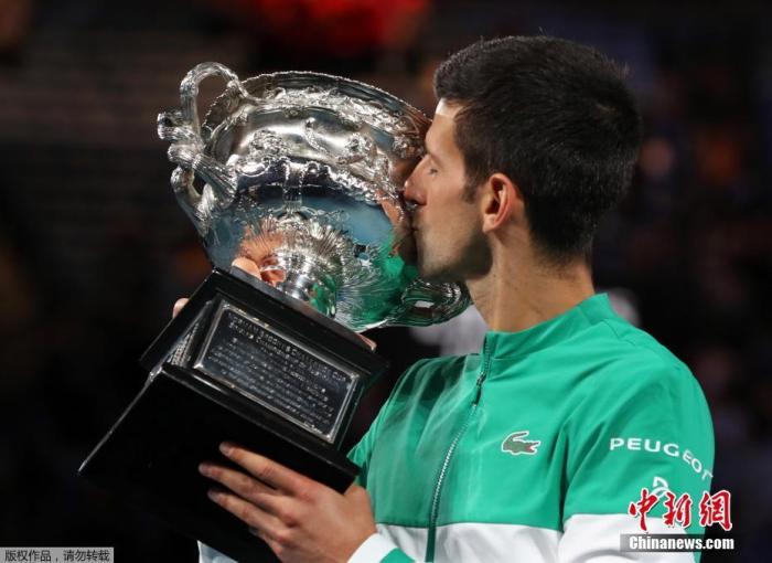 图为德约科维奇亲吻奖杯。