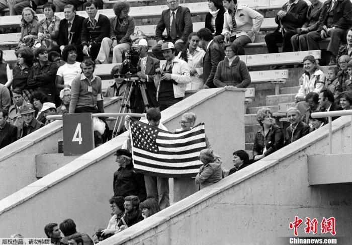 为了抗议1979年12月苏联入侵阿富汗，以美国为首的许多国家联合抵制了莫斯科奥运会。图为莫斯科奥运会开幕式上几名观众在看台上高举美国国旗。