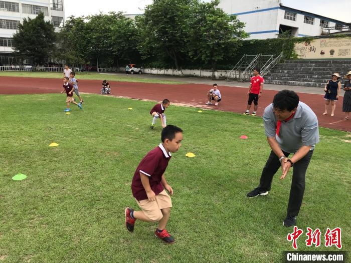 2019年,迟尚斌在柳州27中及附小(前上汽通用五菱子弟学校)辅导职工子弟进行足球训练。 张旭阳 摄 2019年,迟尚斌在柳州27中及附小(前上汽通用五菱子弟学校)辅导职工子弟进行足球训练。 张旭阳 摄