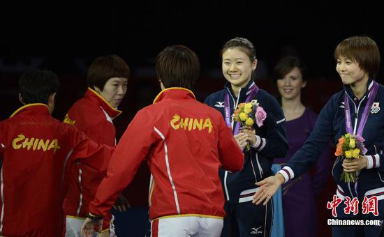 当地时间8月7日,2012伦敦奥运会乒乓球女子团体决赛中,中国队以3-0横扫日本队摘得金牌。三场比分分别为:李晓霞3-1战胜福原爱,丁宁3-0战胜石川佳纯,李晓霞郭跃3-1战胜石川佳纯平野早矢香。图为福原爱祝贺中国女乒。记者 廖攀 摄 当地时间8月7日,2012伦敦奥运会乒乓球女子团体决赛中,中国队以3-0横扫日本队摘得金牌。三场比分分别为:李晓霞3-1战胜福原爱,丁宁3-0战胜石川佳纯,李晓霞郭跃3-1战胜石川佳纯平野早矢香。图为福原爱祝贺中国女乒。记者 廖攀 摄
