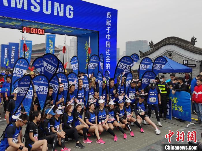 图为赛事配速员在西安城墙上拍照留念。 党田野 摄 图为赛事配速员在西安城墙上拍照留念。 党田野 摄