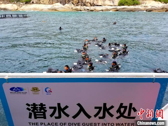 三亚蜈支洲岛,潜水教练浮在海面,等待体验潜水的游客。 记者王晓斌 摄 三亚蜈支洲岛,潜水教练浮在海面,等待体验潜水的游客。 记者王晓斌 摄