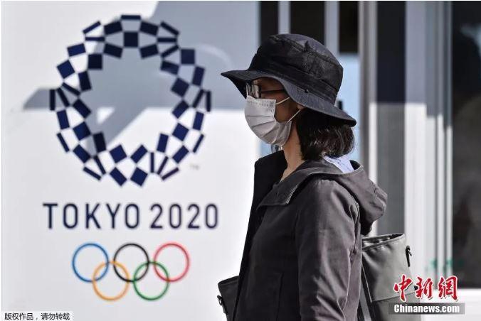 一名女士走过2020年东京奥运会海报。