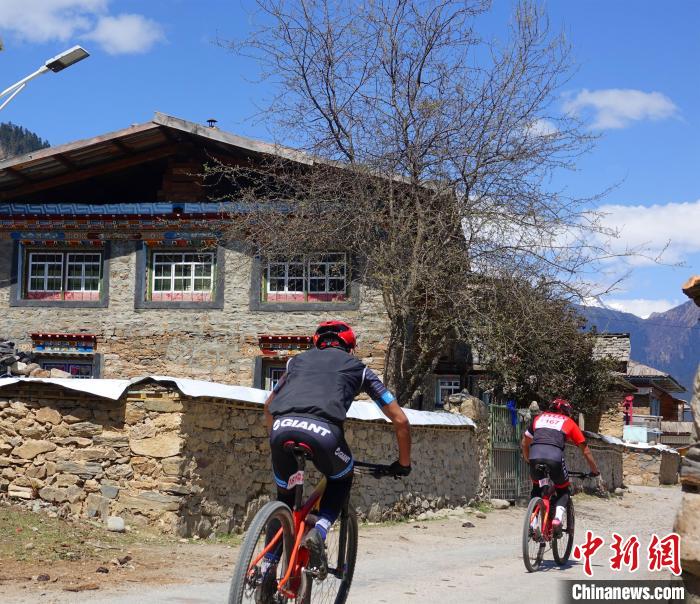 图为参赛选手经过沿线村庄。 冉文娟 摄 图为参赛选手经过沿线村庄。 冉文娟 摄