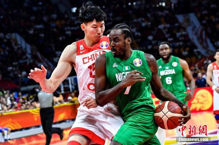 中国队球员周琦(左)在比赛中防守尼日利亚球员阿米奴(中)的上篮。当晚，2019年国际篮联篮球世界杯17-32名排位赛继续进行，在广州举行的M组一场比赛中，中国(白)73比86不敌尼日利亚(绿)。/p中新社记者 陈骥旻 摄