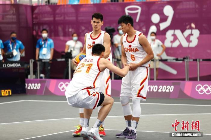 当地时间7月24日，中国选手胡金秋(中)被队友拉起。当日，东京奥运会三人篮球比赛在东京青海城市运动公园举行。在一场小组循环赛中，中国男队13：22不敌塞尔维亚队。 /p中新社记者 富田 摄