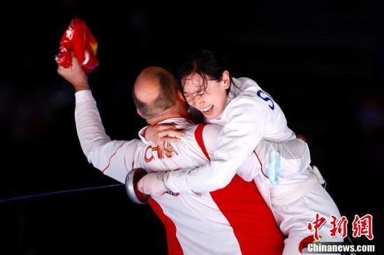 7月24日晚，东京奥运会女子重剑个人赛结束了决赛的较量，中国选手孙一文以11：10战胜罗马尼亚选手波佩斯库，夺得冠军。图为孙一文夺冠后和团队成员一起庆祝。/p中新社记者 富田 摄
