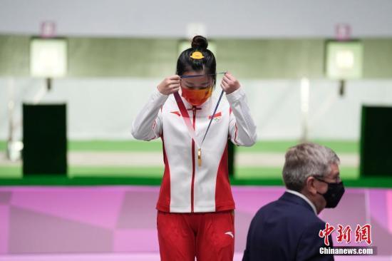 资料图：7月24日举行的东京奥运会女子10米气步枪决赛中，中国选手杨倩夺得冠军，为中国代表团揽入本届奥运会第一枚金牌。这也是本届东京奥运会诞生的首枚金牌。图为杨倩戴上奥运金牌。/p中新社记者 杜洋 摄