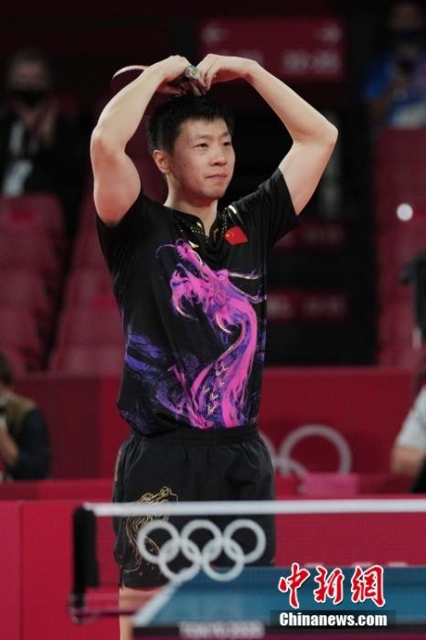7月30日晚，东京奥运会乒乓球男单决赛迎来中国选手“内战”。最终马龙以4：2战胜樊振东，成功卫冕冠军。这是中国代表团在本届奥运会的第19金。图为马龙在比赛结束后比心。/p中新社记者 韩海丹 摄