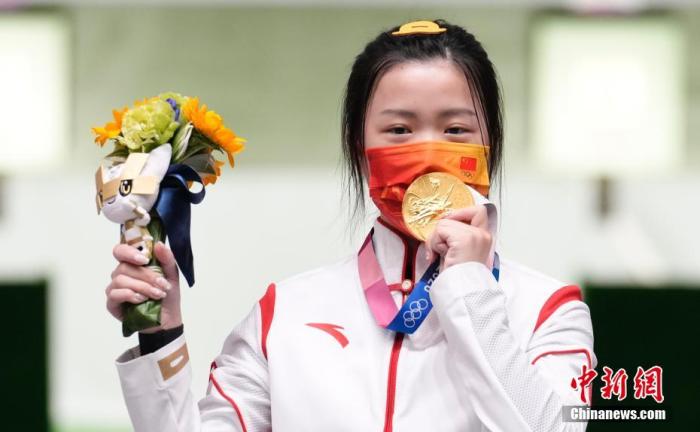 7月24日举行的东京奥运会女子10米气步枪决赛中，中国选手杨倩夺得冠军，为中国代表团揽入本届奥运会第一枚金牌。这也是本届东京奥运会诞生的首枚金牌。图为杨倩隔着口罩亲吻金牌。/p中新社记者 杜洋 摄