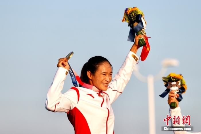 北京时间7月31日，在东京奥运会女子帆板RS：X级奖牌赛中，中国选手卢云秀发挥出色，获得该项目金牌。这也是中国代表团在本届奥运会上的第20枚金牌。图为卢云秀高举金牌。 /p中新社记者 富田 摄