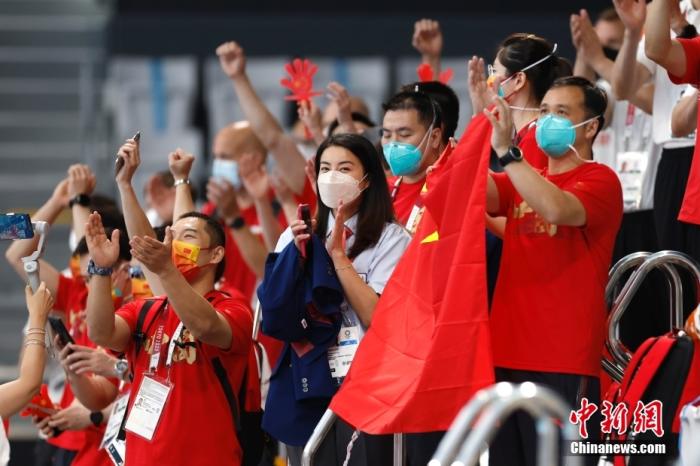 当地时间7月25日，郭晶晶(中)为施廷懋、王涵助威。当日，东京奥运会跳水女子双人三米板决赛在东京水上运动中心举行，中国组合施廷懋、王涵以326.40分摘得金牌。 /p中新社记者 富田 摄