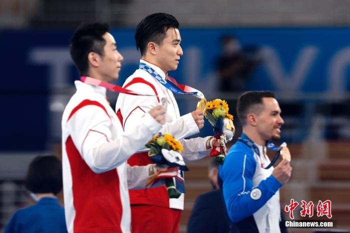 北京时间8月2日，在东京奥运会男子体操单项吊环的比赛中，中国选手刘洋以15.500分夺得冠军。这是中国代表团本届比赛的第26金。另一位中国选手尤浩获得亚军。图为刘洋(中)与尤浩(左)展示金银牌。 /p中新社记者 富田 摄