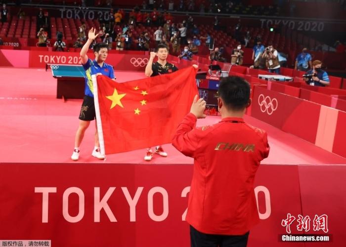 7月30日晚，东京奥运会乒乓球男单决赛迎来中国选手“内战”。最终马龙以4：2战胜樊振东，成功卫冕冠军。这是中国代表团在本届奥运会的第19金。图为赛后两位选手披国旗合影。