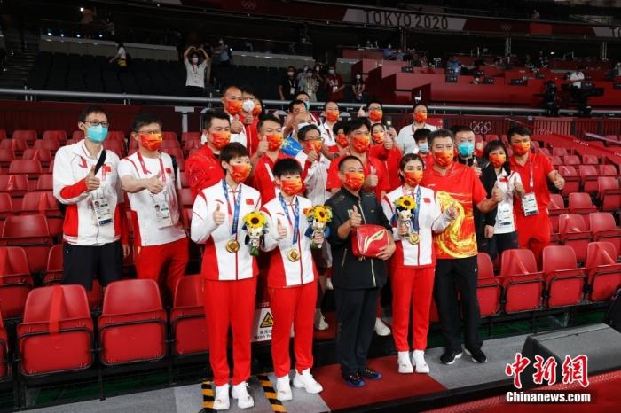 8月5日晚，在东京奥运会女乒团体决赛中，由陈梦、孙颖莎、王曼昱组成的中国队3：0战胜日本队，获得冠军。这是国乒本届奥运会得到的第三枚金牌，也是中国代表团在东京奥运会的第34金。图为赛后合影。 /p中新社记者 韩海丹 摄