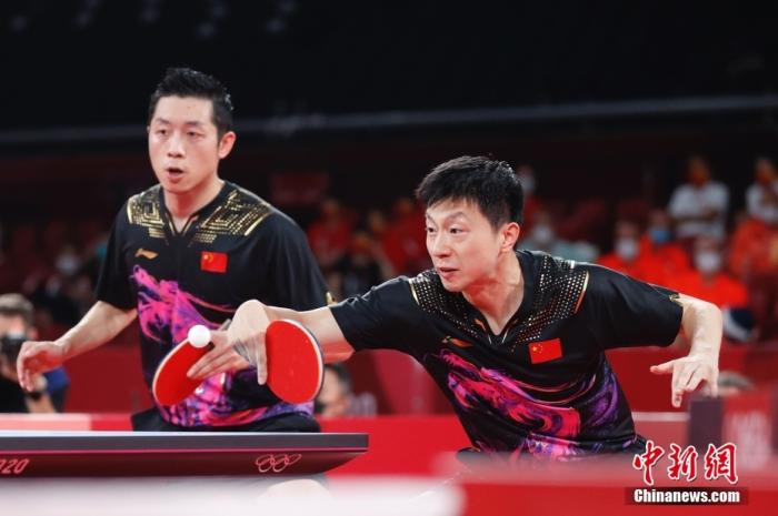 北京时间8月6日晚，在东京奥运会乒乓球男团决赛中，由马龙、樊振东和许昕组成的中国队以3：0战胜德国队，获得冠军。图为许昕(左)与马龙(右)在比赛中。 /p中新社记者 韩海丹 摄