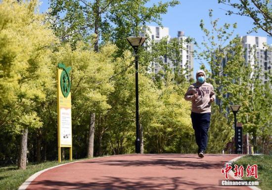 资料图：4月23日，一位市民在北京市朝阳区望京文化体育公园内跑步锻炼。/p中新社记者 侯宇 摄