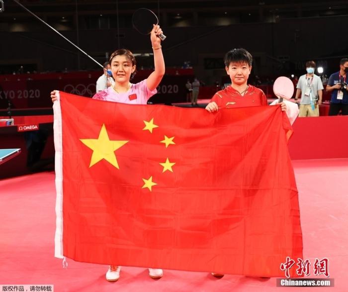 7月29日，东京奥运女单决赛，由中国乒乓球队的陈梦对阵孙颖莎，上演国乒女单内战。在这场代表着如今世界乒坛最高水平的女单对决中，最终陈梦4：2战胜孙颖莎，夺得东京奥运会乒乓球女单冠军。图为比赛结束后陈梦和孙颖莎一起展示中国国旗。