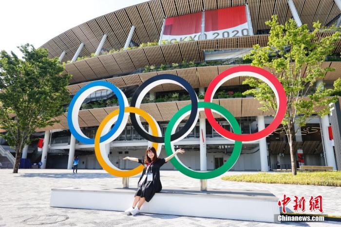 图一位女士与奥运五环标志合影。 /p中新社记者 韩海丹 摄