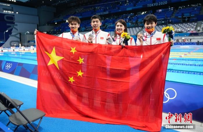 北京时间7月31日,东京奥运会4×100米男女混合泳接力决赛,徐嘉余、闫子贝、张雨霏、杨浚瑄组成的中国队以3分38秒86的成绩摘得一枚银牌,中国队收获4×100米男女混合泳接力项目的首枚奖牌。图为赛后中国队队员展示中国国旗。 中新社记者 杜洋 摄 北京时间7月31日,东京奥运会4×100米男女混合泳接力决赛,徐嘉余、闫子贝、张雨霏、杨浚瑄组成的中国队以3分38秒86的成绩摘得一枚银牌,中国队收获4×100米男女混合泳接力项目的首枚奖牌。图为赛后中国队队员展示中国国旗。 /p中新社记者 杜洋 摄