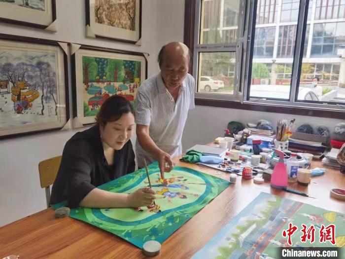 西安户县农民画画家正在作画。　西安市鄠邑区融媒体中心供图