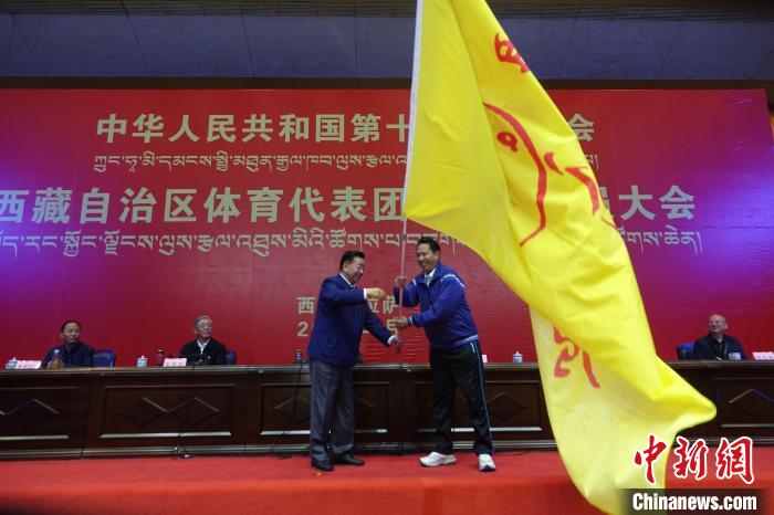 西藏自治区副主席甲热·洛桑丹增授代表团团旗,西藏自治区体育局局长尼玛次仁接旗。 冉文娟 摄 西藏自治区副主席甲热·洛桑丹增授代表团团旗,西藏自治区体育局局长尼玛次仁接旗。 冉文娟 摄