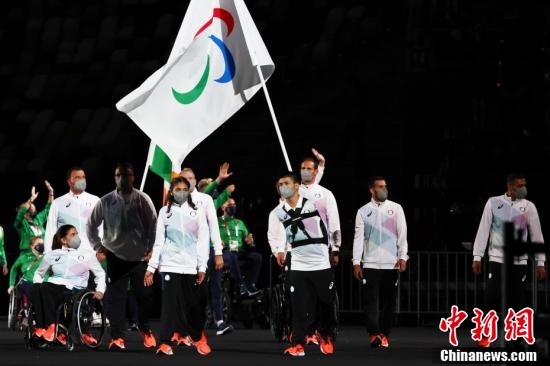 8月24日，2020东京残奥会开幕式在东京新国立竞技场举行。图为东京残奥会难民代表团步入场内。